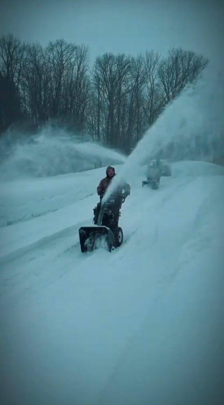 Snowblower clearing a deep residential driveway